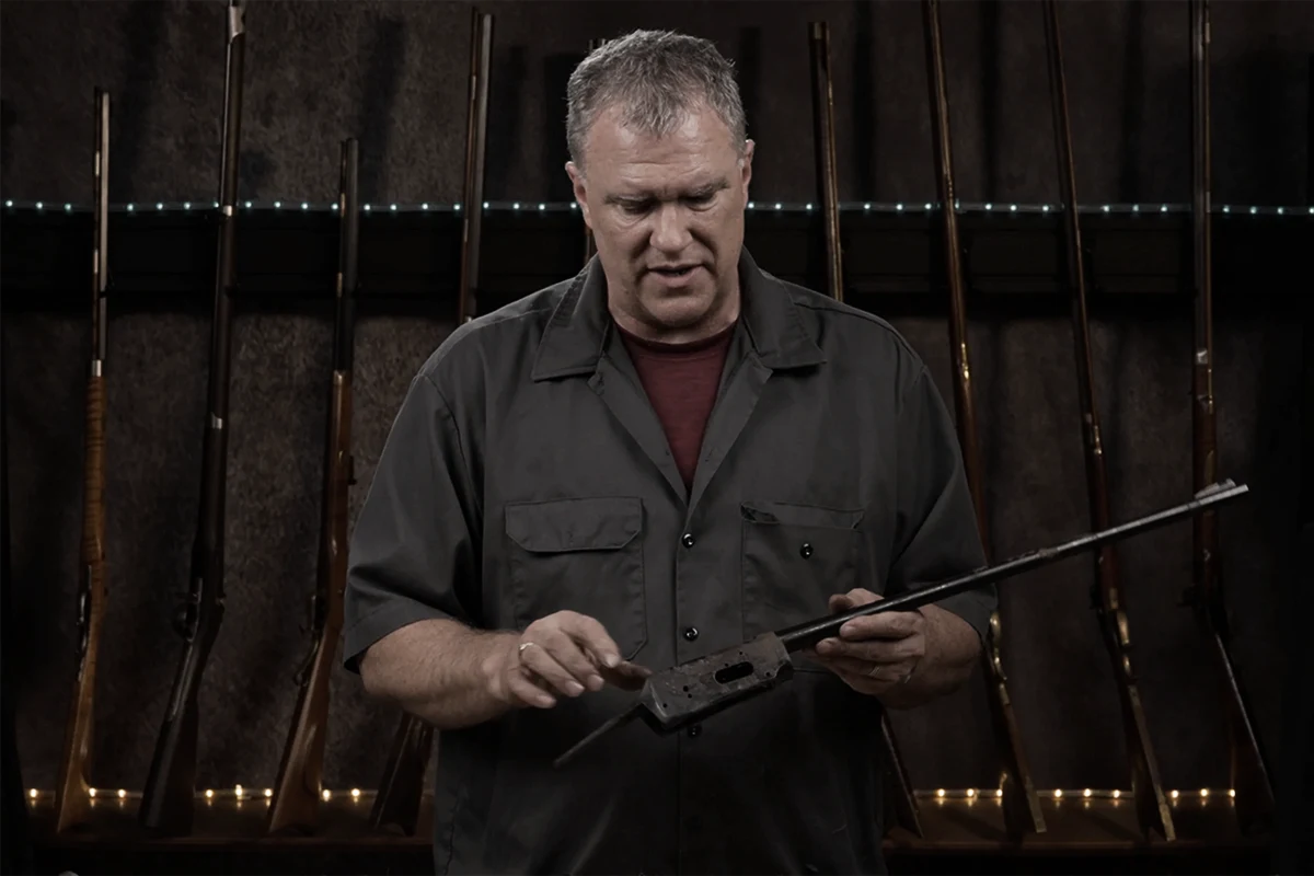 Paul Lippold examining a pitted rifle receiver at the RGS Restorations shop in Wisconsin